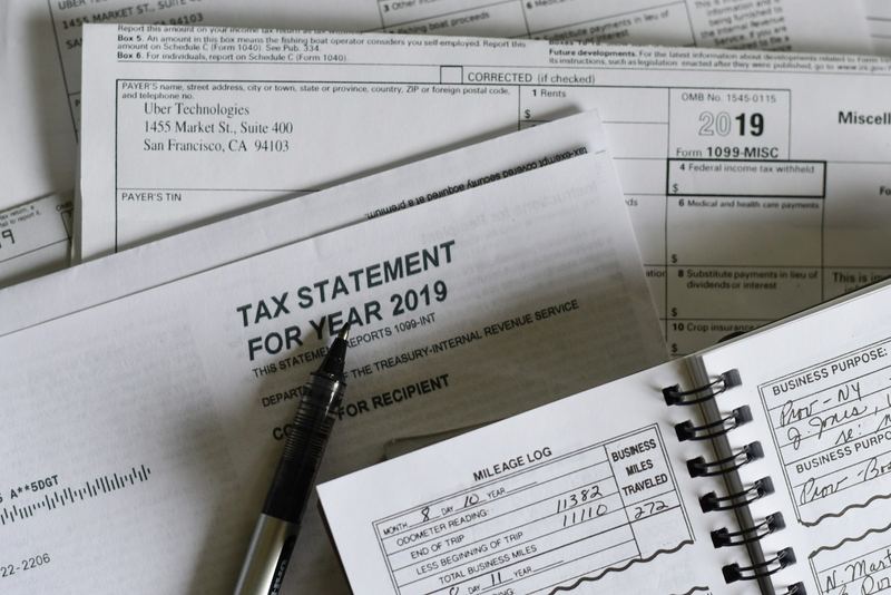 A pen resting on tax paperwork next to a calculator