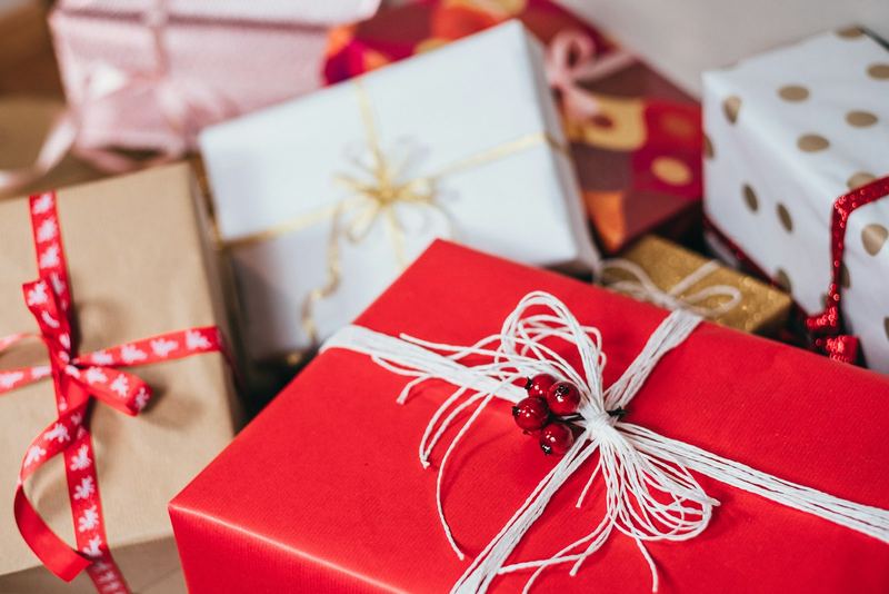 Wrapped gift boxes tied with ribbon, stacked on a table