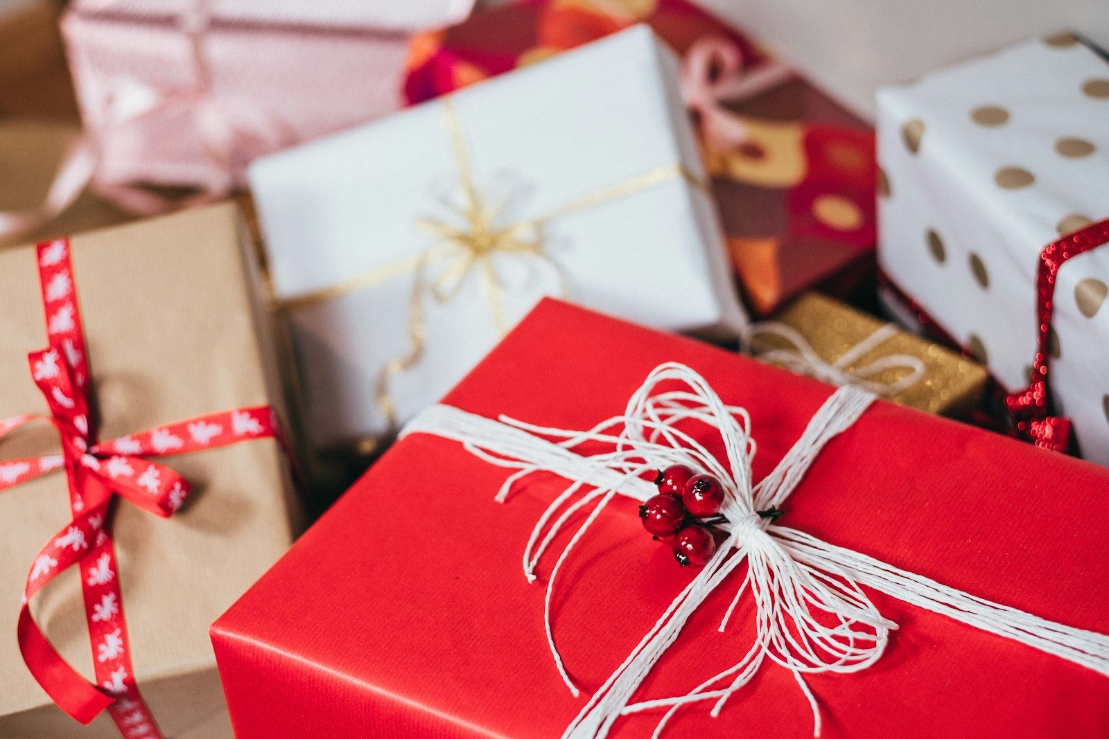 Wrapped gift boxes tied with ribbon, stacked on a table